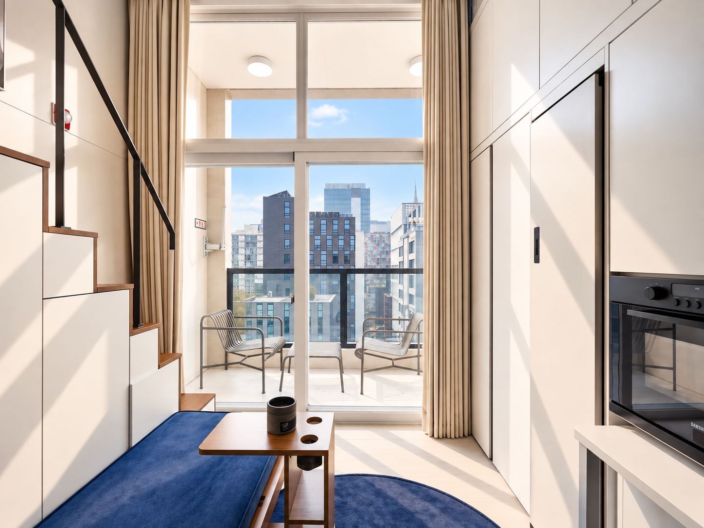 A modern apartment with a balcony, a dining area, and a kitchen.