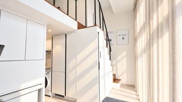 A modern apartment with a kitchen, living area, and a staircase.