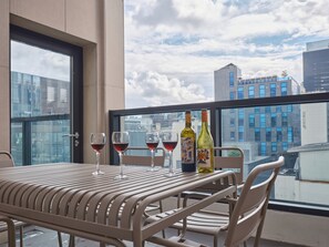 A balcony with a table, four wine glasses, and two bottles of wine. - UH FLAT SIGNATURE GANGNAM (Seoul)