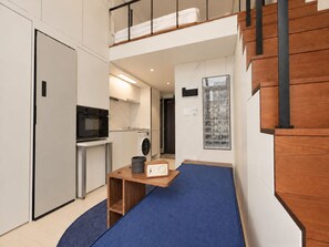 A compact kitchen with a microwave, washing machine, and a small table with a radio. - UH FLAT SIGNATURE GANGNAM (Seoul)