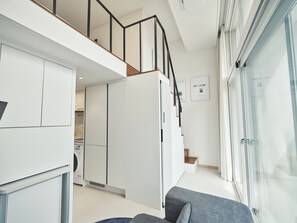 A modern apartment with a kitchen, a dining area, and a living room with a sofa. - UH FLAT SIGNATURE GANGNAM (Seoul)