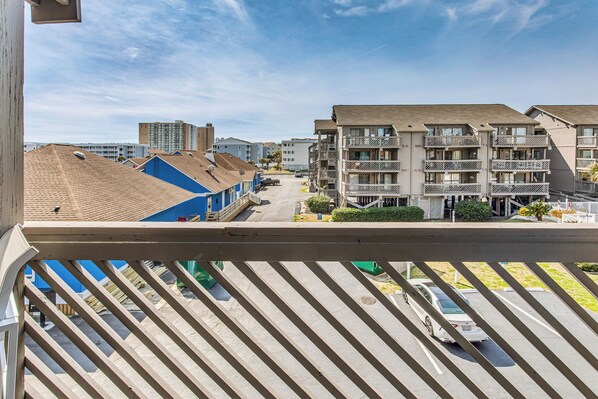 A residential area with multi-story buildings, a parking lot, and a clear sky. - Walk to Ocean: Condo w/ 3 Pools in Myrtle Beach (Myrtle Beach)