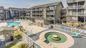 A hotel with multiple balconies, a swimming pool, and a sun deck with lounge chairs. - Walk to Ocean: Condo w/ 3 Pools in Myrtle Beach (Myrtle Beach)