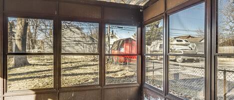 A room with large windows, a concrete floor, and a metal ceiling.