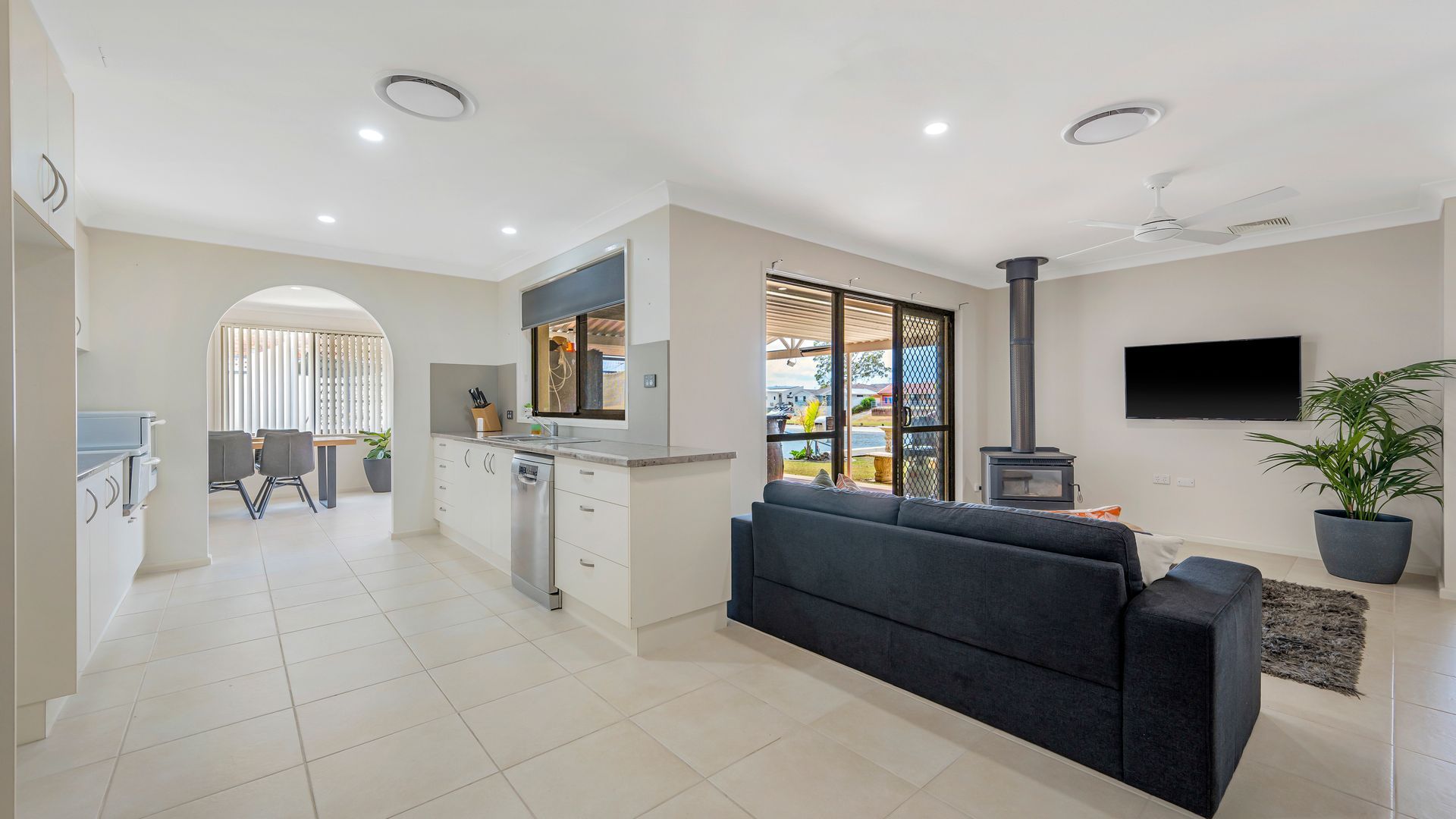 A modern living space with a kitchen, dining area, and a cozy seating area with a fireplace.