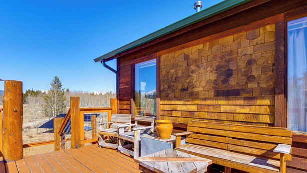 A wooden deck with outdoor seating and a large window. - Mtn-view Getaway w/ On-site Trails in Fairplay! (Fairplay)