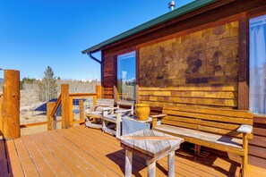 A wooden deck with outdoor seating and a large window. - Mtn-view Getaway w/ On-site Trails in Fairplay! (Fairplay)