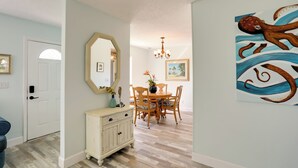 A dining area with a wooden table and chairs, a white cabinet, and a chandelier. - Townhome Near Hobe Sound Beach, Hiking & Golfing! (Hobe Sound)