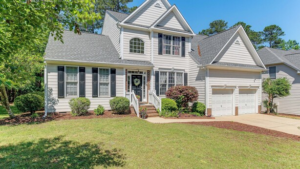 A two-story house with a front porch, a garage, and a well-maintained lawn. - Fire Pit + Pool Access: Quiet Holly Springs Home (Holly Springs)