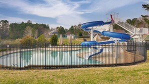 A swimming pool with a water slide and a fenced area. - Fire Pit + Pool Access: Quiet Holly Springs Home (Holly Springs)