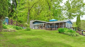A house with a deck, a stone wall, and a staircase leading to a porch. - Walk to Lake! Home w/ Private Dock in Alpine (Alpine)
