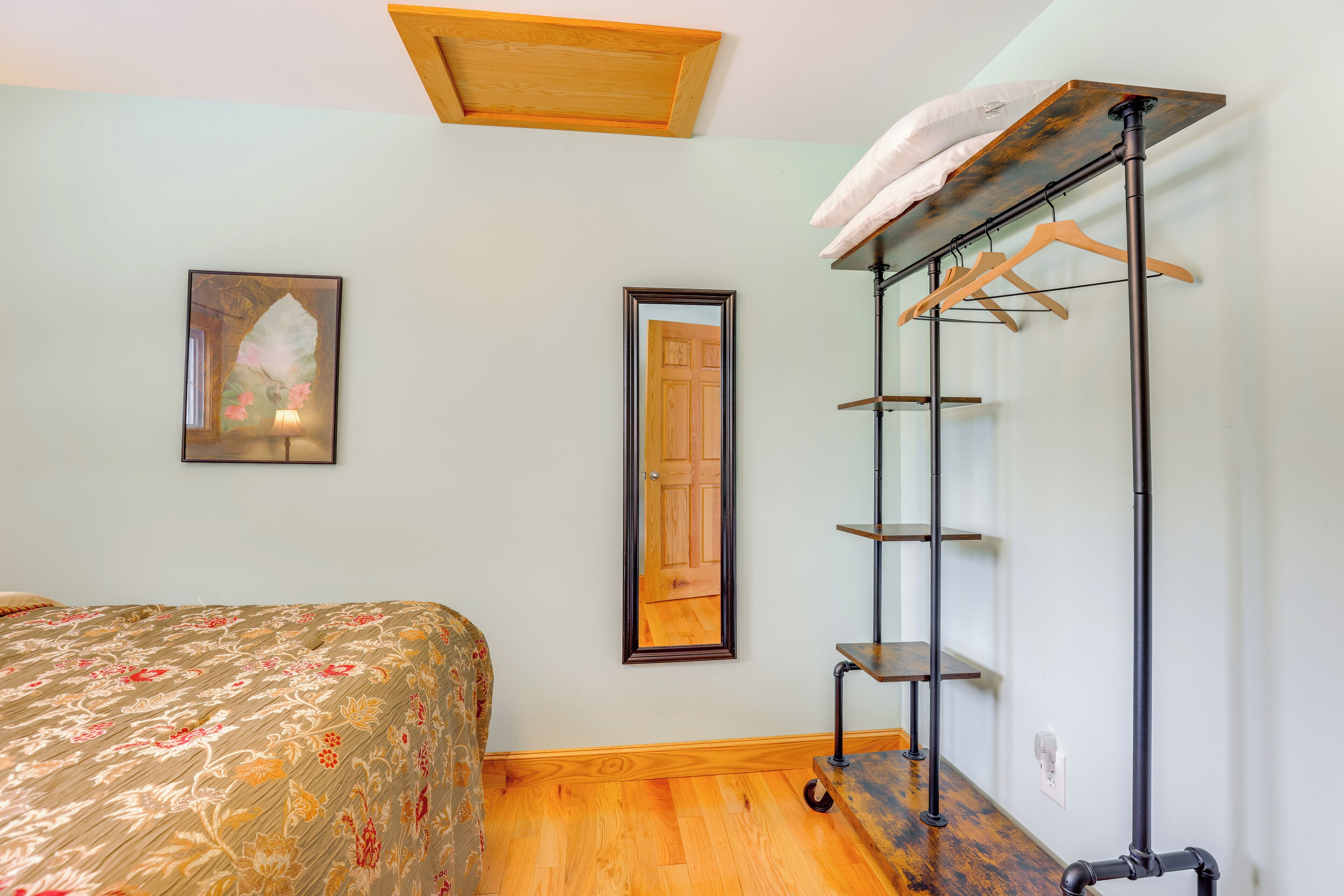 Una camera da letto con un letto, un armadio, uno specchio e una lampada a soffitto.