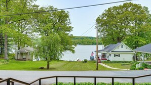 A lakeside view with two houses, a dock, and a flag. - Walk to Lake! Home w/ Private Dock in Alpine (Alpine)