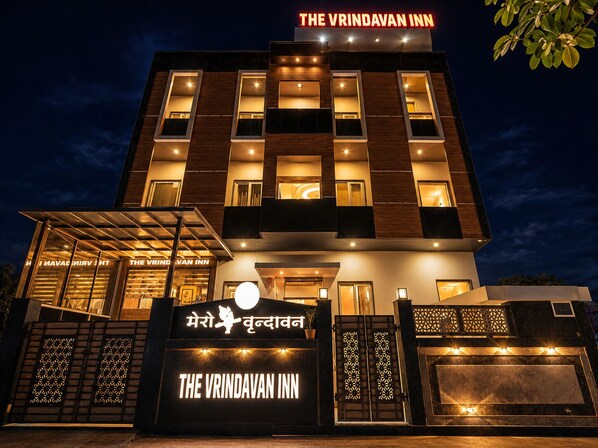 A modern building with a sign reading 'The Vrindavan Inn' and a logo with a cat.