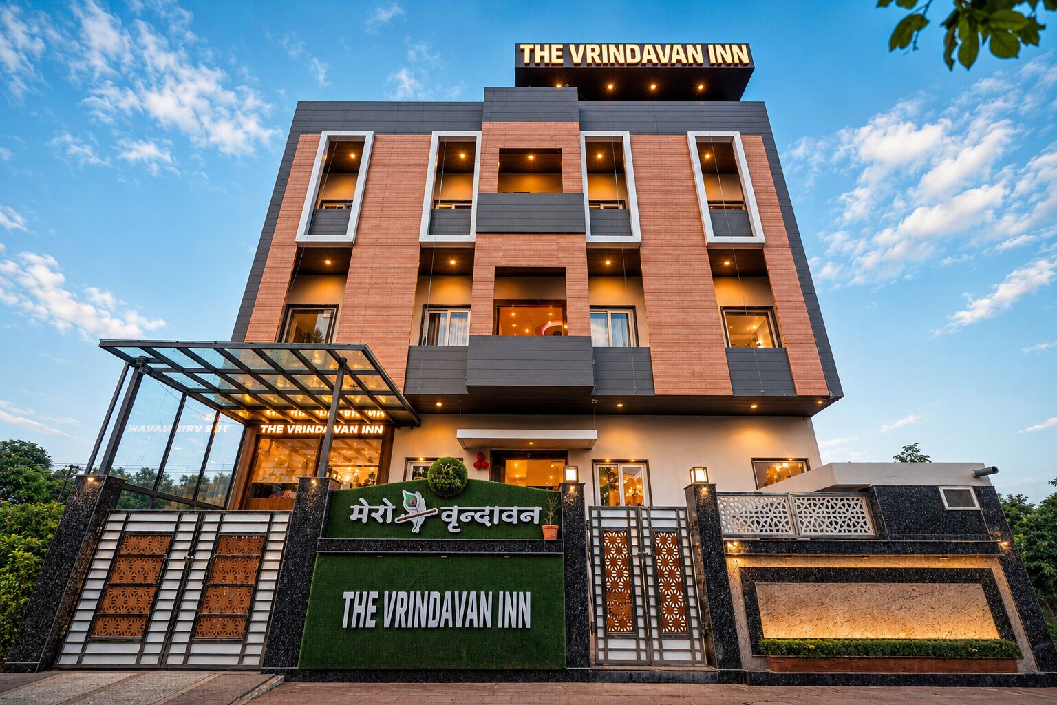 A multi-story building with a sign reading 'The Vrindavan Inn' and a signboard with 'Mero Kundav' in a local script.