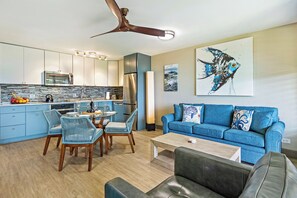 Una cucina moderna con zona pranzo, un divano blu e una ventola a soffitto.