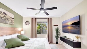 A bedroom with a bed, a ceiling fan, a TV, a window with curtains, a clock, and a plant. - The Gator Escape -Poolside Condo walk to Tiki Bar (Clewiston)