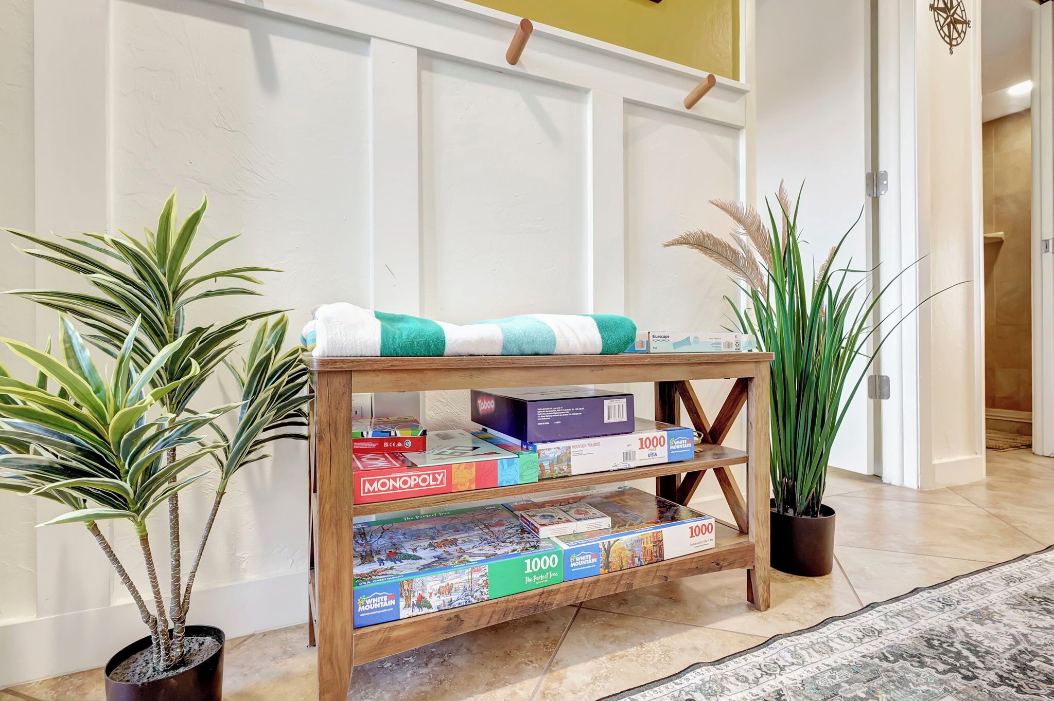 A wooden console table with board games and a blanket.