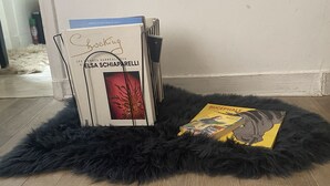 Une pièce avec un tapis noir à poils longs, un mur blanc et un plancher en bois.