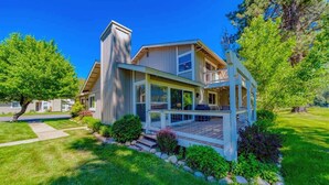 A modern two-story house with a covered porch, a chimney, and a well-maintained lawn. - Perfect in the Pines - 38 Aspen Circle (Plumas Eureka)