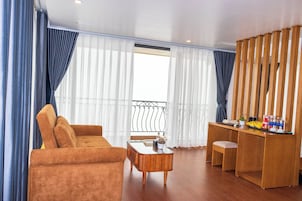 Una sala de estar con un sofá, una mesa de centro y un escritorio de madera con una silla.