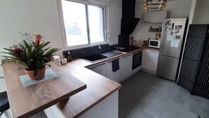 Une cuisine moderne dotée d’un plan de travail en bois, d’un évier, d’une cuisinière, d’un four à micro-ondes et d’un réfrigérateur.