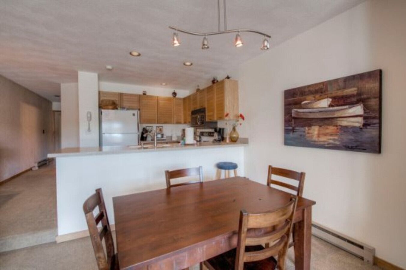 A spacious kitchen with wooden cabinets, a central island, and pendant lighting.