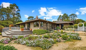 A modern house with a patio, surrounded by a garden with various plants and flowers. - 3971 La Sieste - Beautiful Garden, Mountain Views (Carmel)