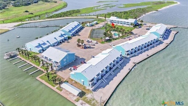 An aerial view of a waterfront property with multiple buildings, a dock, and a marina. - Beauty By The Bay K702 1 Bedroom Condo (Rockport)