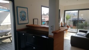 A modern kitchen with a wooden countertop, black cabinets, and a sliding glass door leading to a balcony. - Quiet house 200 m from the ocean. (Lacanau)