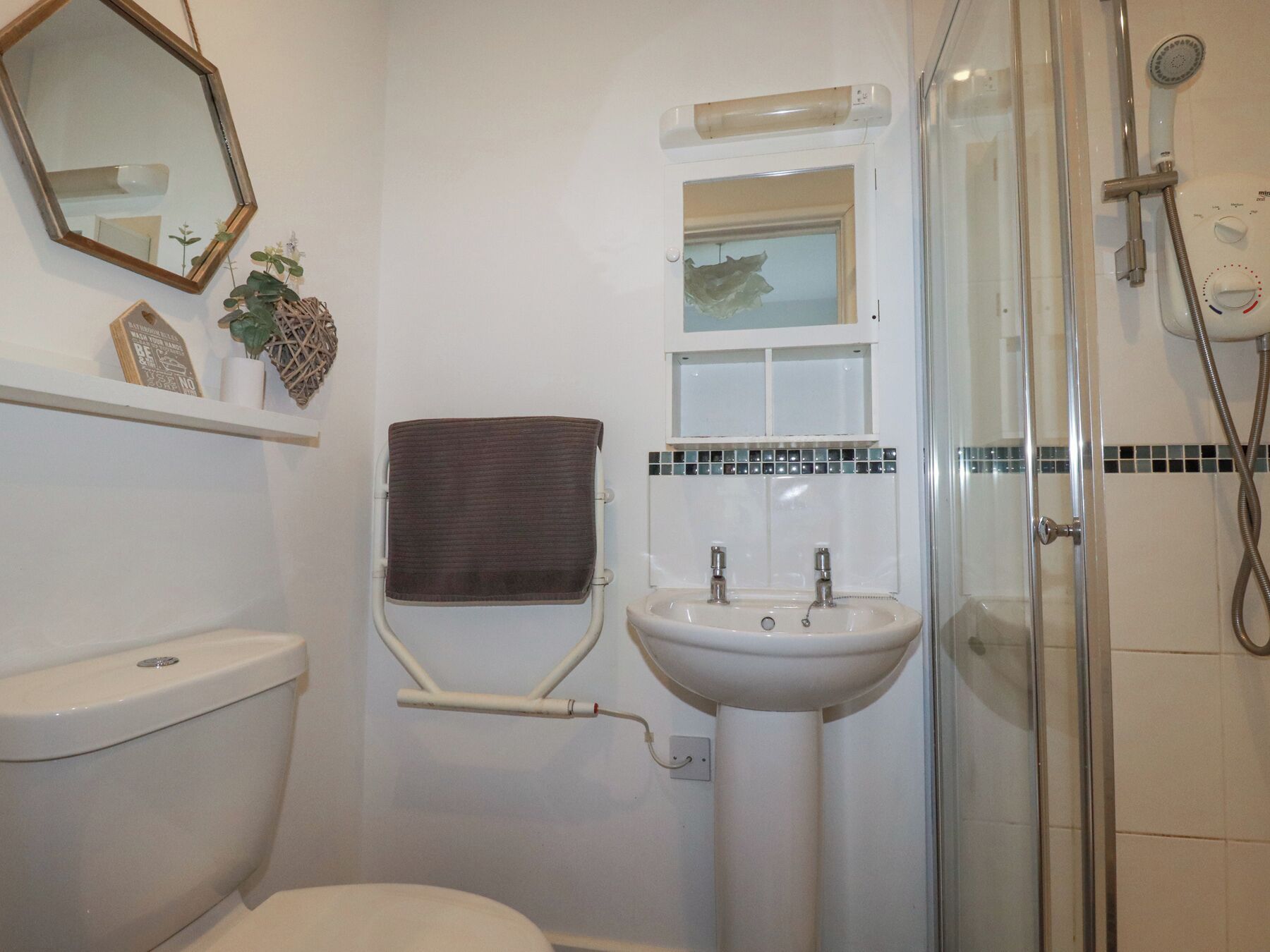 A bathroom with a toilet, sink, and shower.