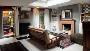 A living room with a skylight, a fireplace, a sofa, and a coffee table. - Chic studio with AC and WiFi in phenomenal Roma (Roma)