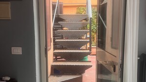A staircase leading to an outdoor area with a brick wall and a door. - Chic studio with AC and WiFi in phenomenal Roma (Roma)