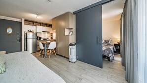 A modern hotel room with a bed, a kitchenette, a dining area, and a separate bedroom. - Modern 1Bedroom,1 bathroom,Terrace,Wash/Dry and WiFi 8min MetroL5 Santiago (Santiago)
