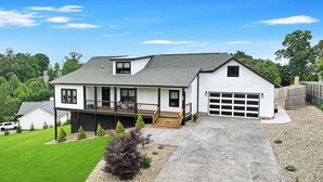 A two-story house with a covered porch, a garage, and a well-maintained lawn.