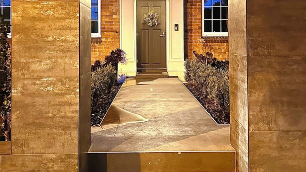 A brick building with a central entrance, a balcony, and two lantern-style lights on either side. - Luxury & Grandeur Hawthorn Apt| Prime Location, Parking ! (Hawthorn)