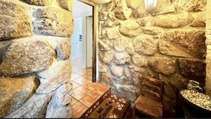 Un couloir aux murs de pierre, avec un banc en bois et une table.