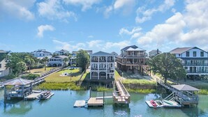 A waterfront property with multiple buildings, docks, and a grassy area with a fountain.