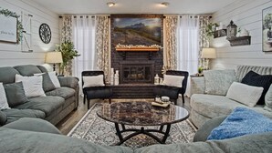 A living room with a fireplace, two sofas, a coffee table, and a rug.
