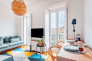 Relax in this stylish living space with a large flat-screen TV, comfortable sofa, and dining area for a meal.