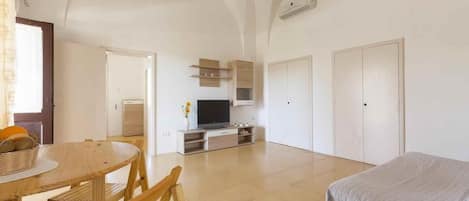 2 dormitorios y tabla de planchar con plancha