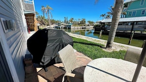 Eine Terrasse im Freien mit überdachtem Grill, einem Tisch und Stühlen.