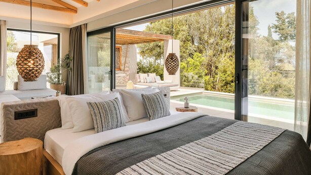 Une chambre moderne avec un grand lit, une vue sur une piscine et un plafond en bois.