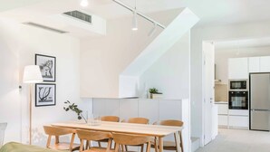 Una cucina moderna con mobili bianchi, forno integrato e microonde.