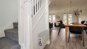 A modern kitchen with a dining area, a staircase, and a view to the outside. - Treveglos (Truro)