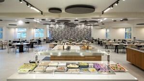 A spacious cafeteria with multiple tables and a central buffet area. - Kalya Kibbutz Hotel (Kalya)