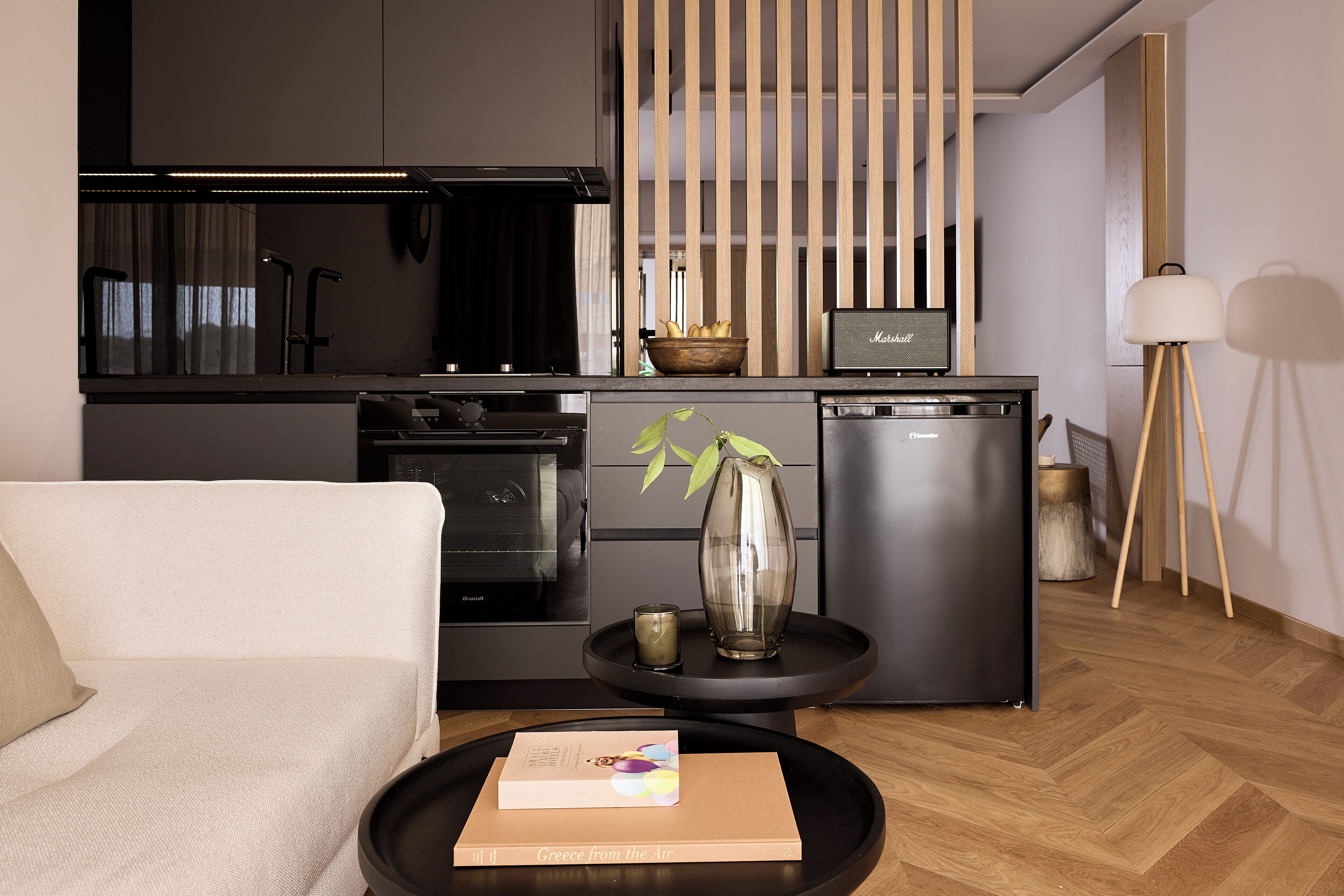 Een moderne keuken met een ingebouwde oven, vaatwasser en een houten kom op het aanrecht.