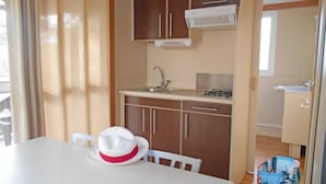A compact kitchen with a sink, stove, and cabinets.