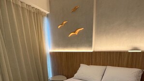 A hotel room with a bed, curtains, a bedside table, and a wall with a light fixture. - Flats no Parque do Cais Recife  (Recife)