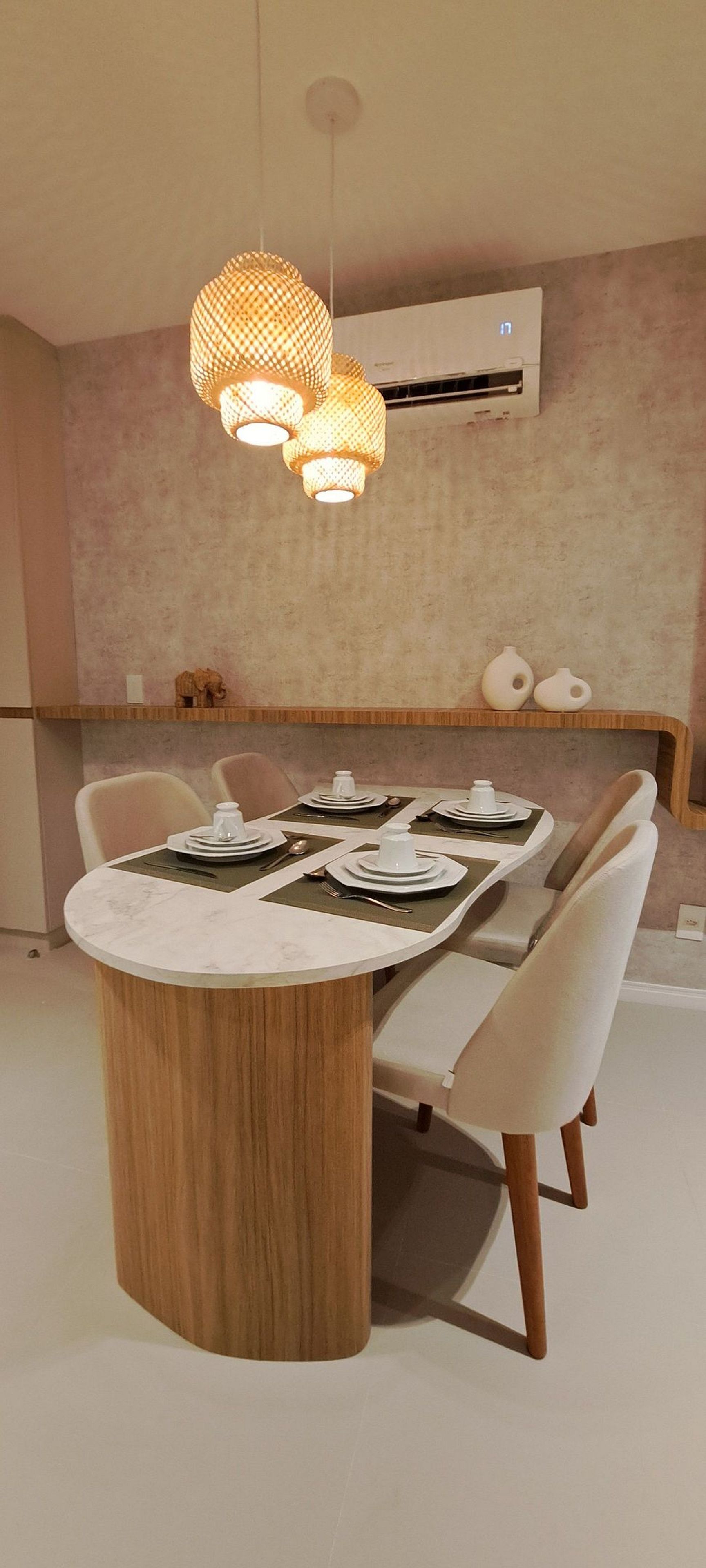A dining area with a round table, chairs, and a pendant light fixture.